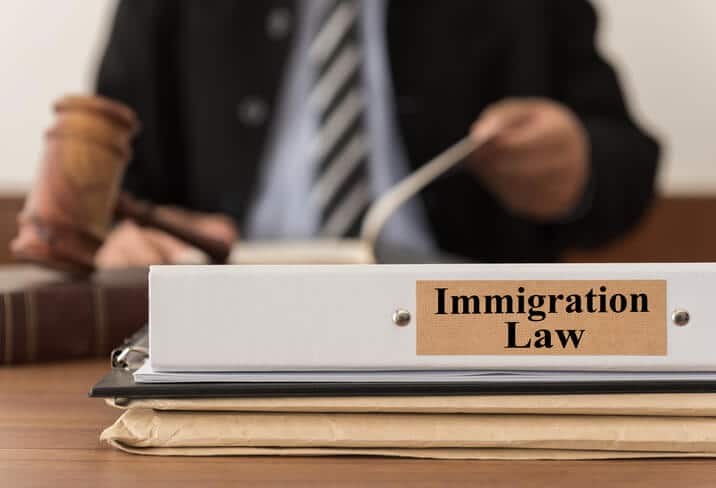 Worried immigrant meeting with a lawyer after criminal charges in New York while facing possible deportation consequences