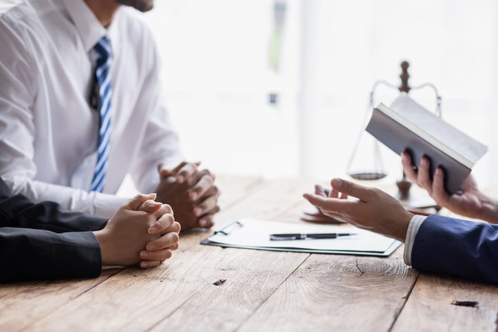 Attorney discussing DWI immigration consequences with a client in a professional legal office.