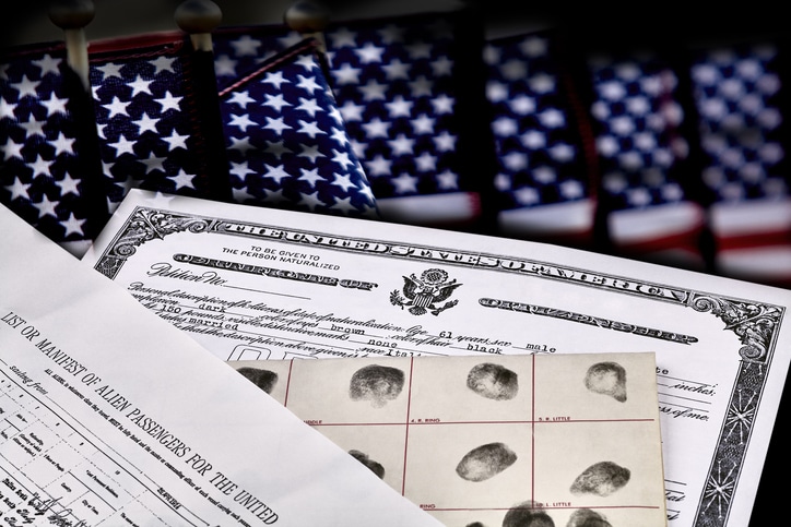 U.S. citizenship documents and fingerprint record displayed with American flags