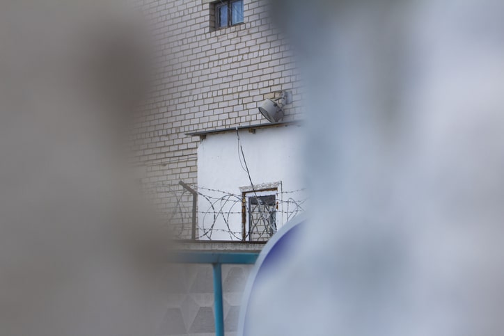 Detention facility behind security fencing representing ICE detention